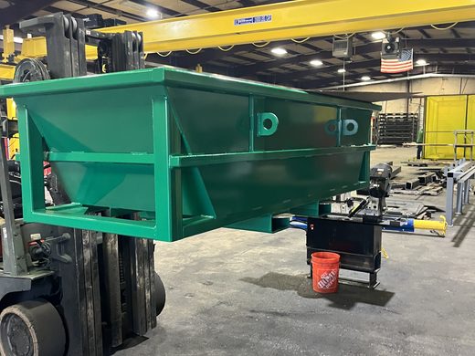 Green steel hopper section carried on a forklift inside the fabrication shop